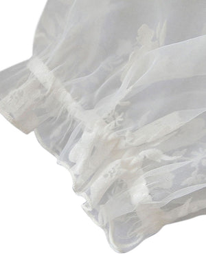 Vista superiore del dettaglio del raccolto del tubo delle maniche corte della camicetta a maniche corte del pizzo floreale casuale